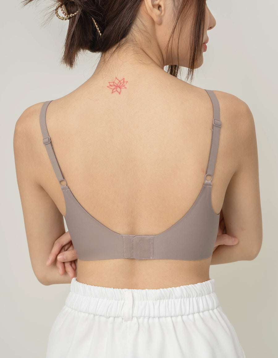 Rear view of Chantelle's Secret Tri-Cup Daily Seamless Bra in taupe, showcasing its sleek design with adjustable straps for a personalized fit.