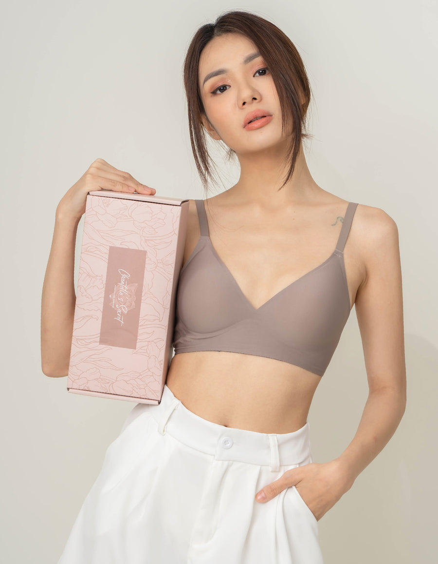 Elegant presentation of Chantelle's Secret Tri-Cup Daily Seamless Bra in a sophisticated taupe, held next to its branded box, ready for the perfect unboxing experience.